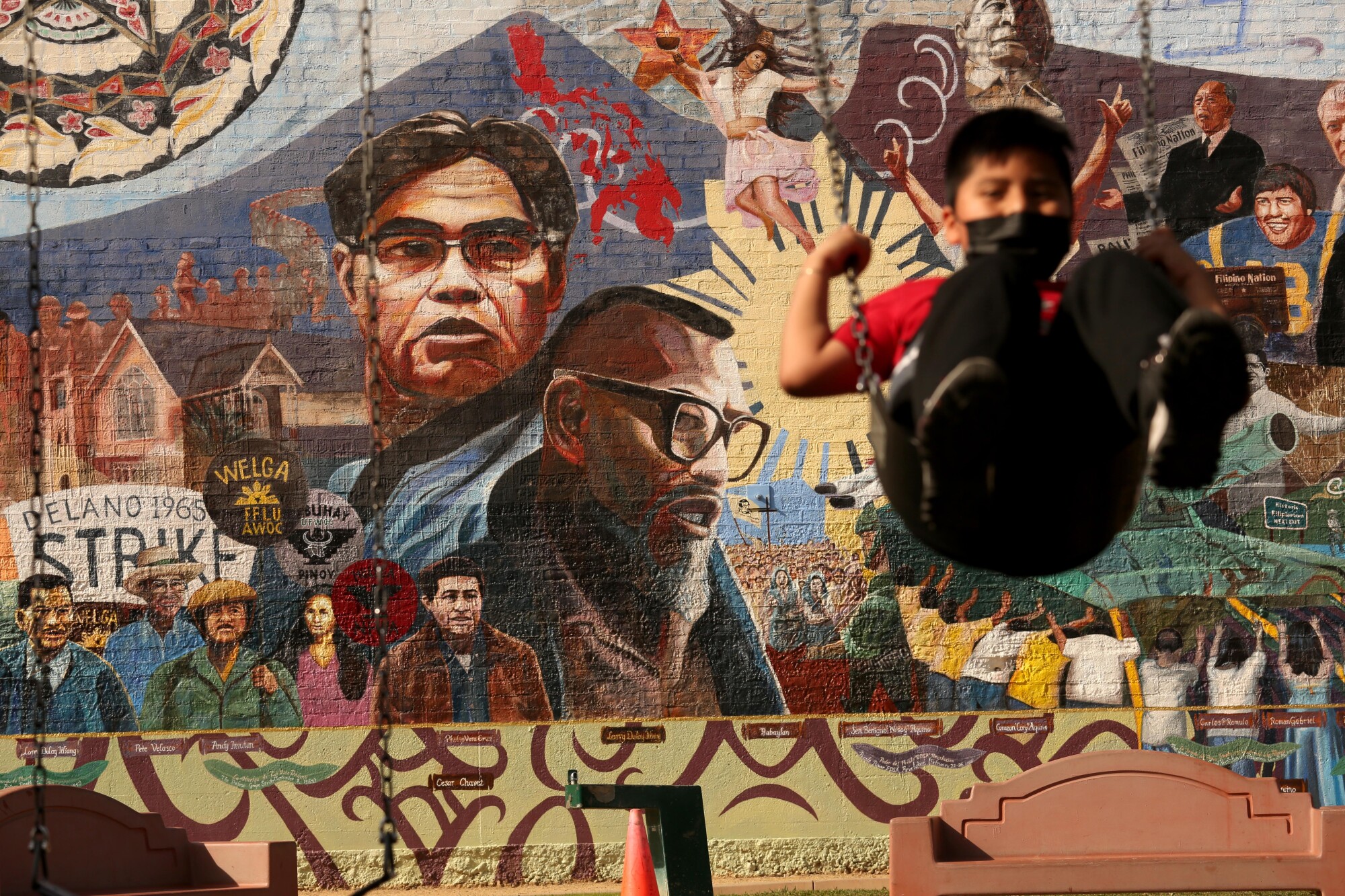 Franklin Lopez, 8, swings in front of a mural in Historic Filipinotown.