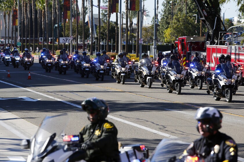 Columns of motorcycle officers with blue and red lights on