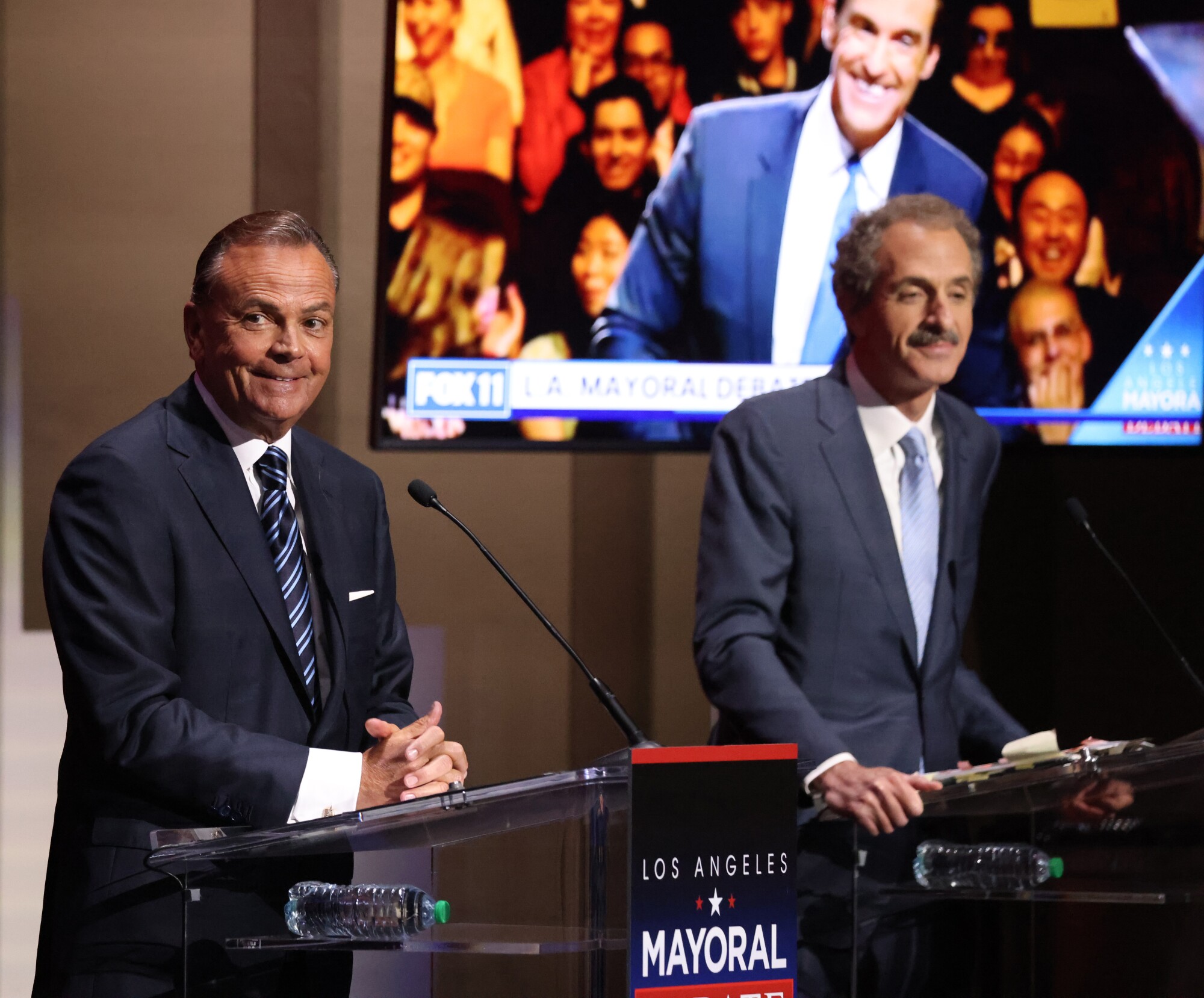 Los Angeles mayoral candidates Rick Caruso, businessman, left, and Mike Feuer, city attorney, listen during the debate 