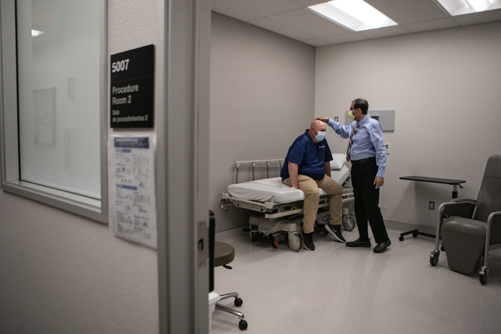 A physician examines a man at the Valley Fever Institute at Kern Medical in Bakersfield.