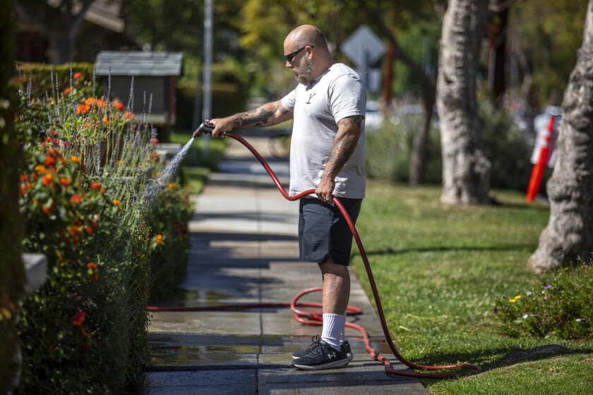 Scott Moses waters flowers in his front yard in South Pasadena.