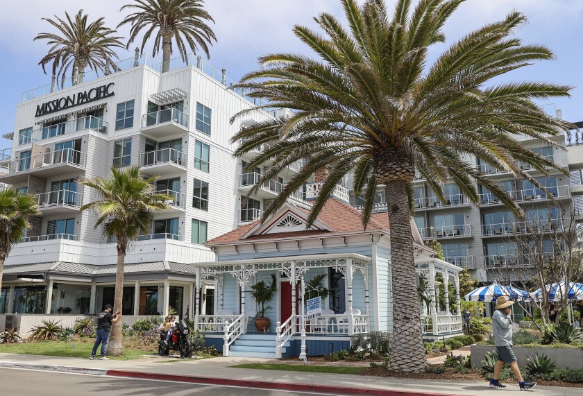 The Victorian cottage sits next to a new hotel in Oceanside.