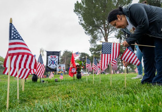Alicia Lopez place flags around her son U.S. Marine Corps...