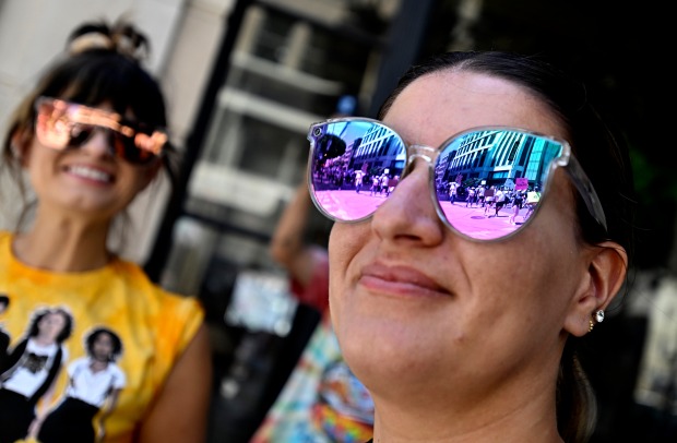 Activists are silhouetted in an onlookers sunglasses as they march...
