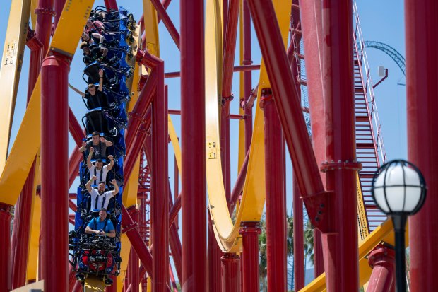 People ride the new Wonder Woman Flight of Courage roller...