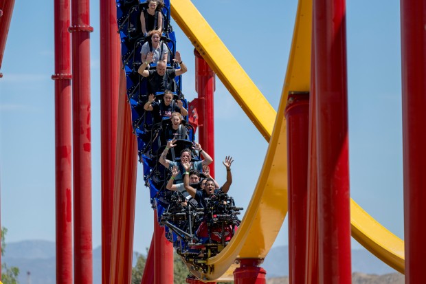 People ride the new Wonder Woman Flight of Courage roller...