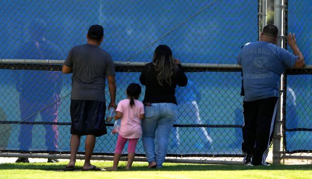 Family and fiends look on as baseball player compete during...